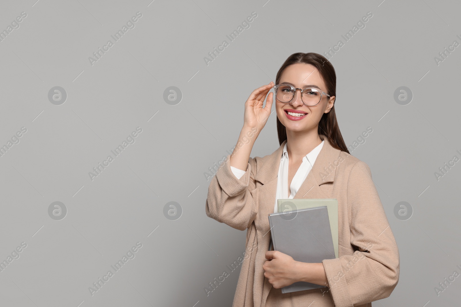 Photo of Portrait of beautiful young teacher on grey background. Space for text