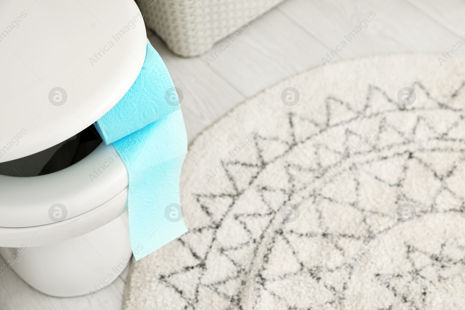 Photo of Toilet bowl with paper roll in bathroom, above view. Space for text