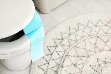 Toilet bowl with paper roll in bathroom, above view. Space for text