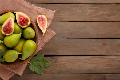 Photo of Cut and whole green figs on wooden table, flat lay. Space for text