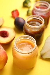 Healthy baby food and ingredients on yellow background