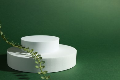 Photo of Product photography props. Round shaped podiums with plant on green background, space for text