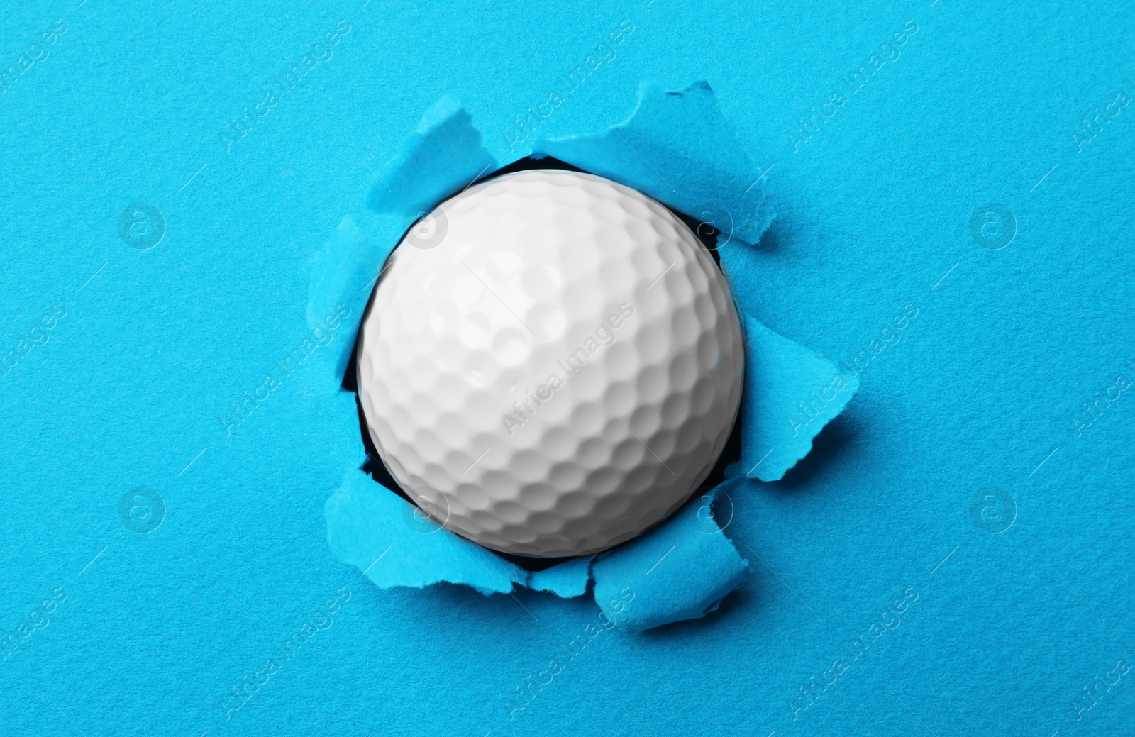 Photo of New golf ball stuck in color paper