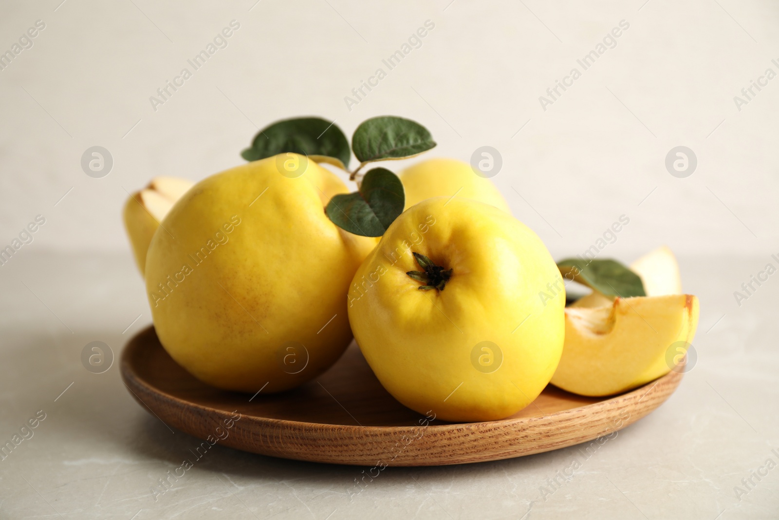 Photo of Fresh ripe organic quinces with leaves on light table