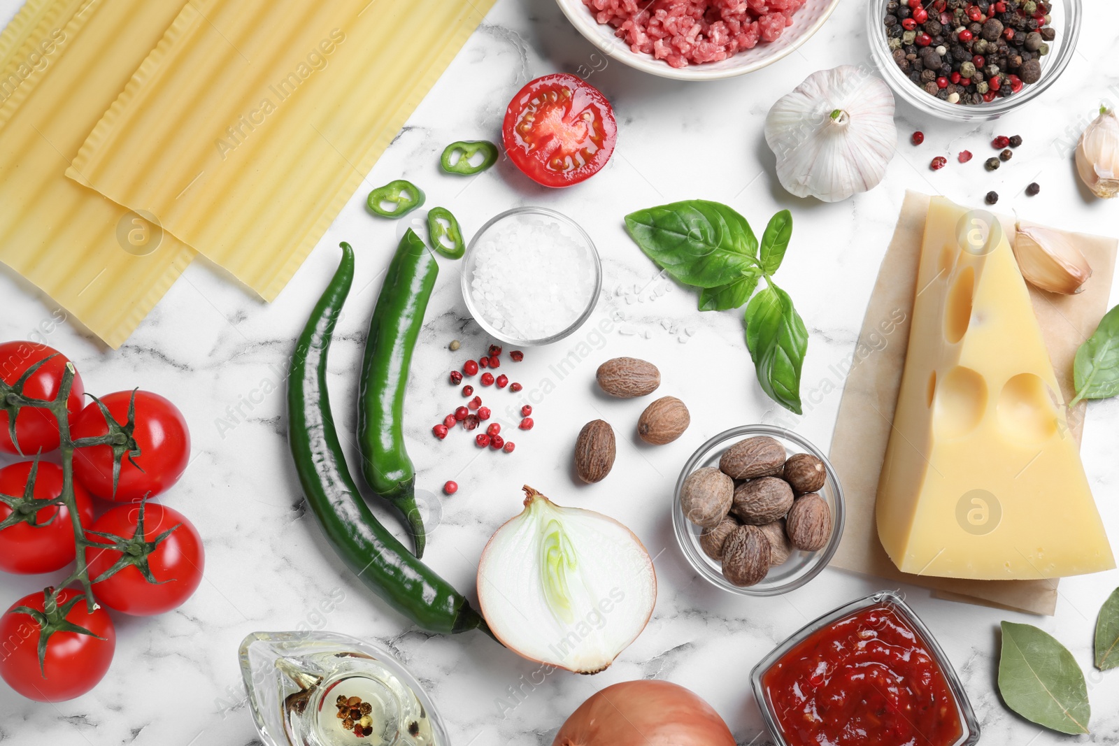 Photo of Fresh ingredients for lasagna on white marble table, flat lay