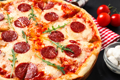 Photo of Hot delicious pepperoni pizza on dark table, closeup