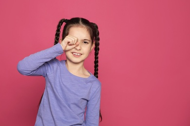 Photo of Little girl rubbing eye on color background, space for text. Annoying itch