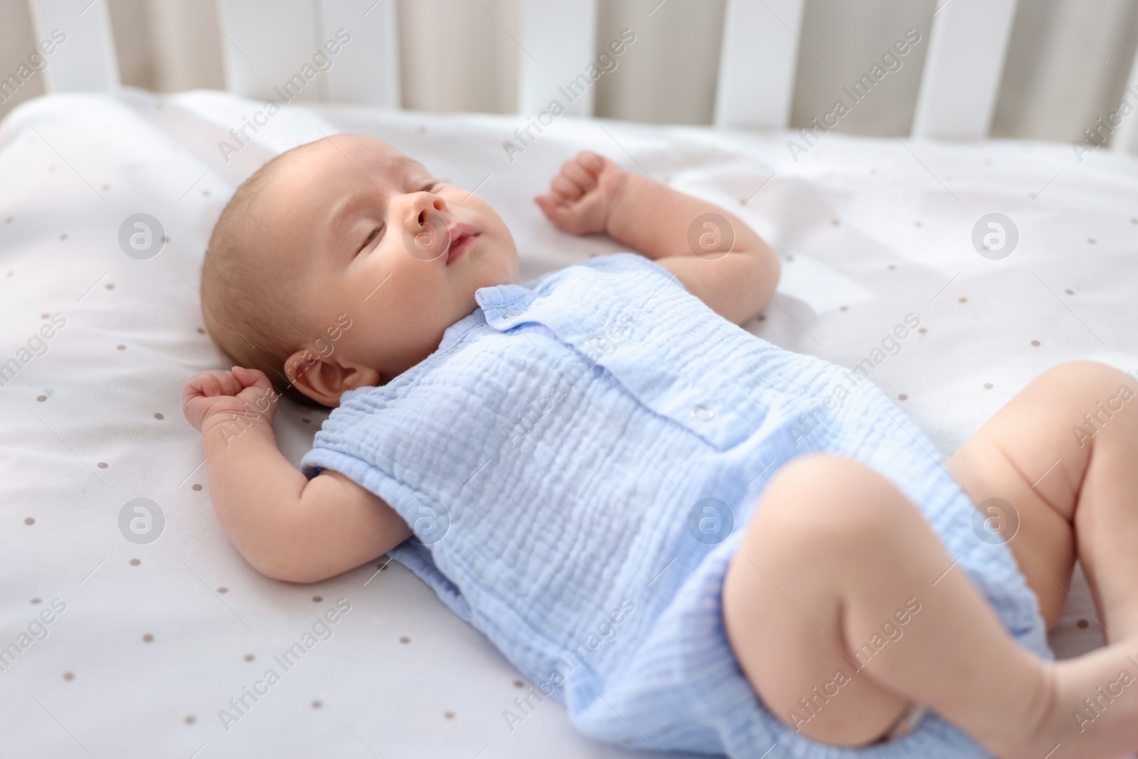 Photo of Cute little baby lying in crib at home