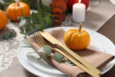 Autumn table setting, pumpkin and eucalyptus branch, closeup