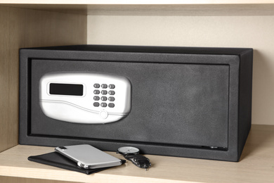 Black steel safe with electronic lock in wooden closet