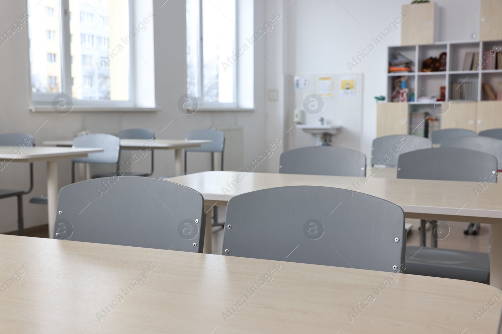 Photo of Empty school classroom with desks and chairs