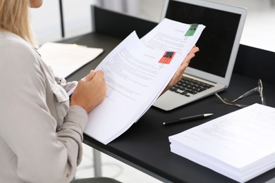 Photo of Businesswoman working with documents at table in office, closeup