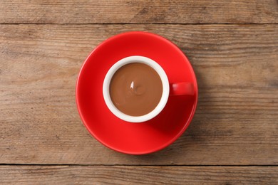 Yummy hot chocolate in cup on wooden table, top view