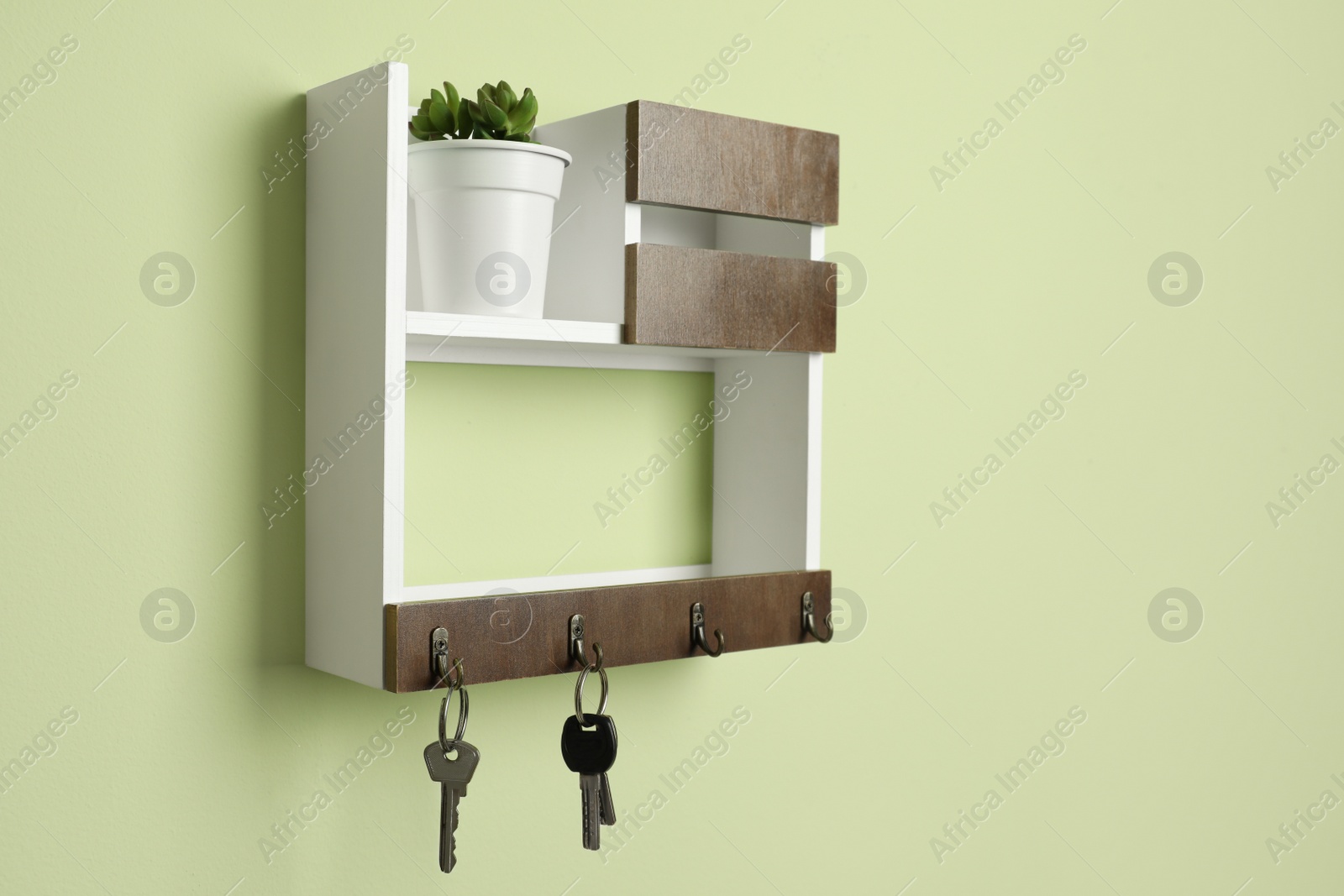 Photo of Wooden hanger for keys on light green wall