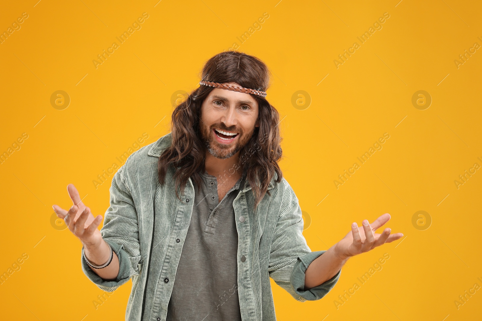 Photo of Stylish hippie man in gray shirt on orange background