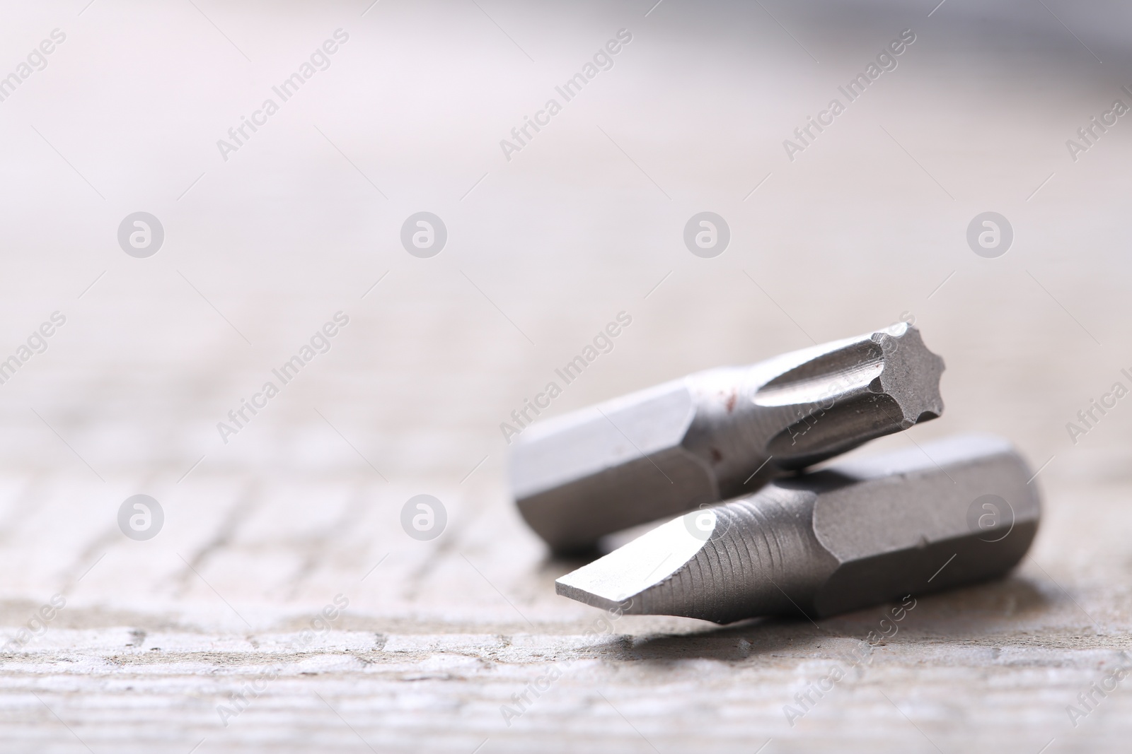 Photo of Different screwdriver bits on wooden table, closeup. Space for text