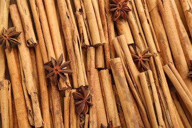 Aromatic cinnamon sticks and anise as background, top view