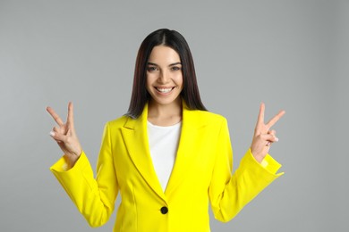 Woman showing number four with her hands on grey background