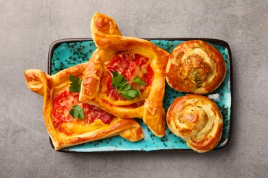 Different delicious puff pastry with tasty filling on grey table, top view