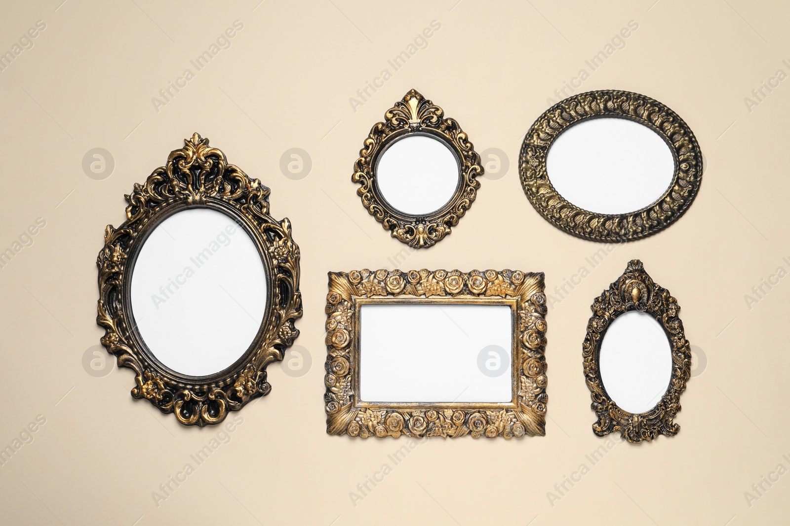 Photo of Empty vintage frames hanging on beige wall