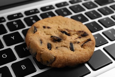 Photo of Chocolate chip cookie on laptop, closeup view