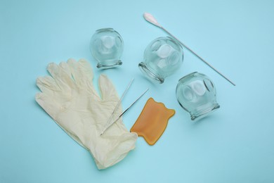 Photo of Flat lay composition with glass cups on light blue background. Cupping therapy