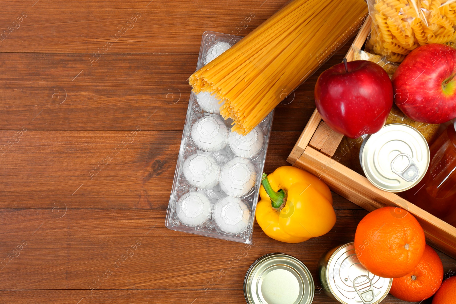 Photo of Humanitarian aid. Different food products for donation on wooden table, flat lay. Space for text