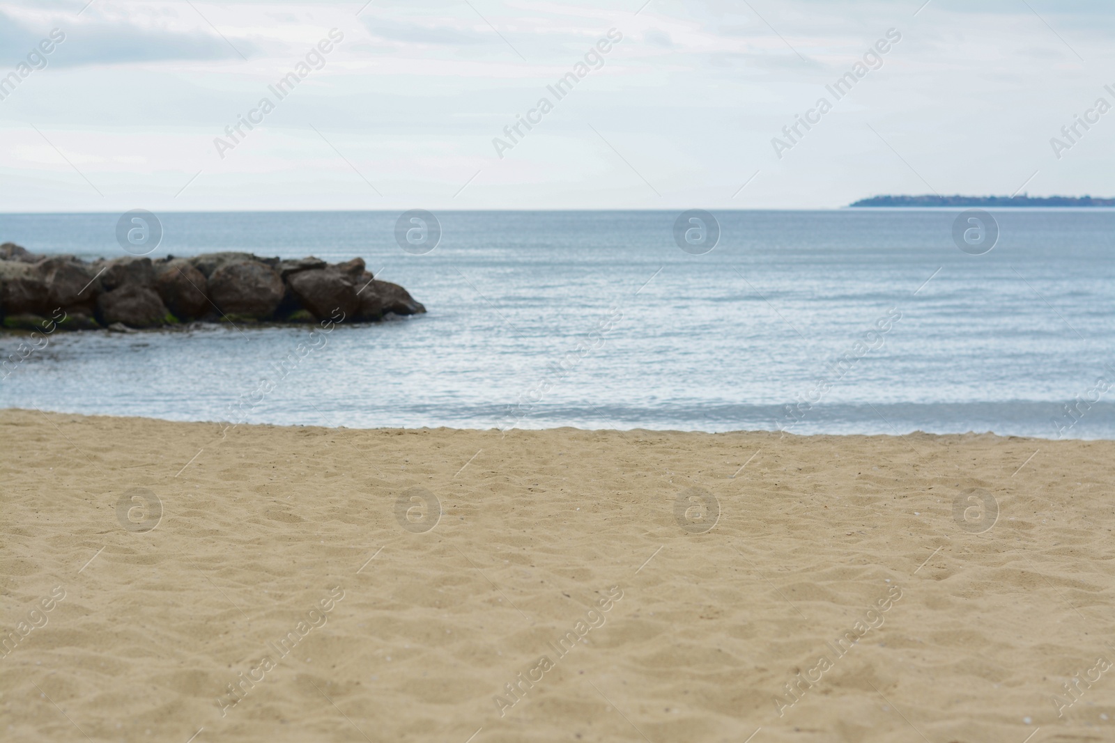 Photo of Beautiful view on sea with rock breakwater near sandy beach