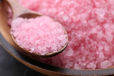 Photo of Spoon and pink sea salt in wooden bowl, closeup