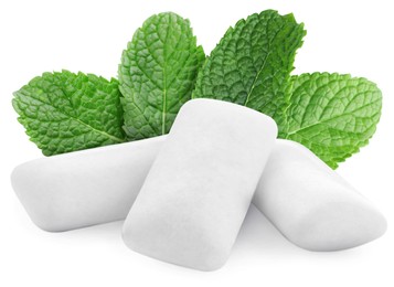 Menthol chewing gum pillows and mint leaves on white background