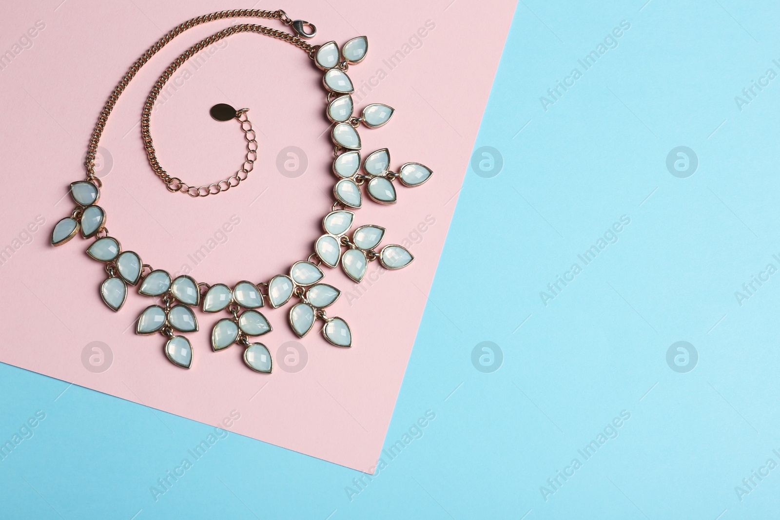 Photo of Elegant necklace on color background, top view with space for text. Luxury jewelry