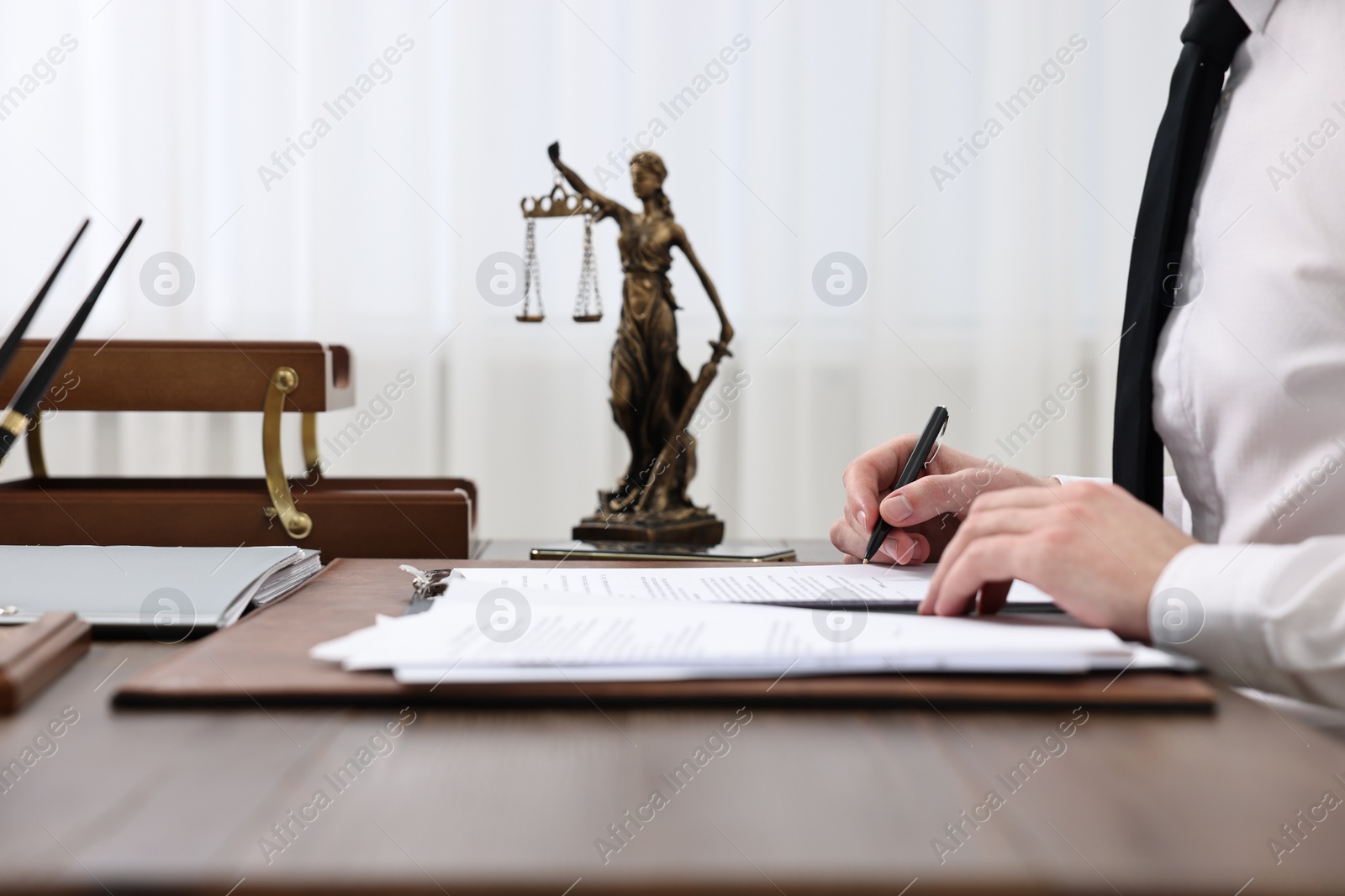 Photo of Lawyer working with documents at wooden table indoors, closeup