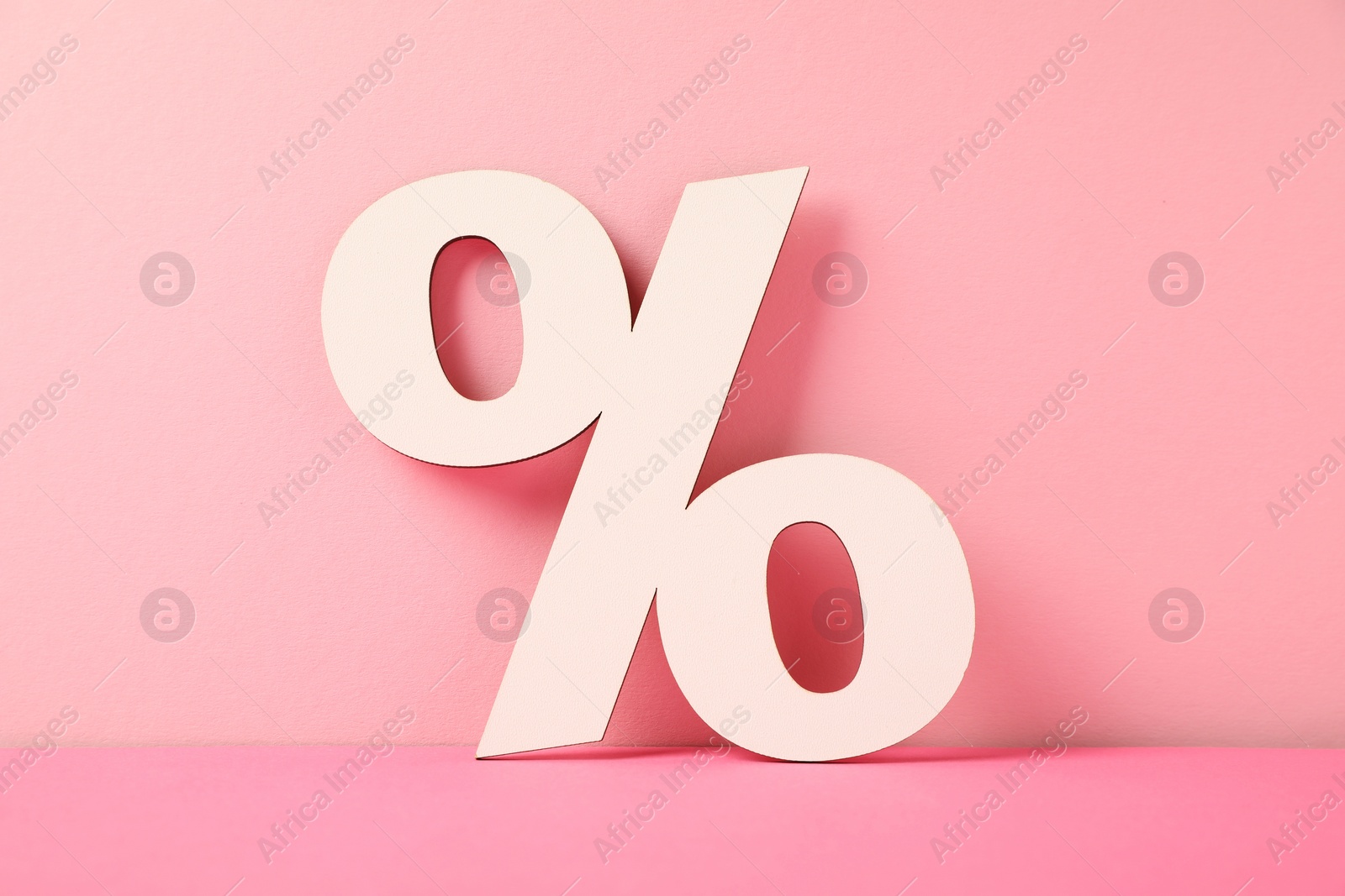 Photo of White wooden percent sign on pink background