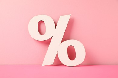 Photo of White wooden percent sign on pink background