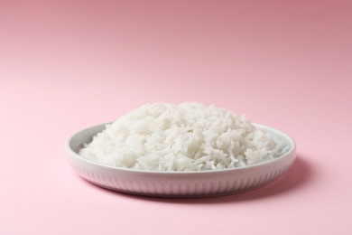 Plate of tasty cooked rice on color background