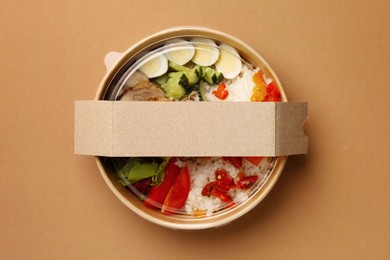 Tasty food in container on beige background, top view. Space for text