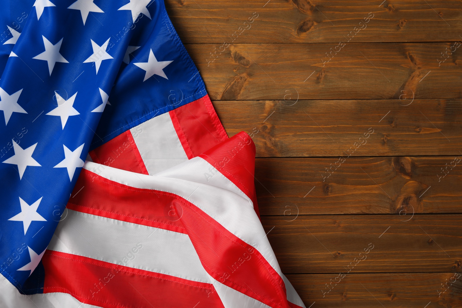 Photo of American flag on wooden table, top view with space for text. Memorial Day