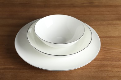 Photo of Stack of ceramic dishware on wooden table, closeup