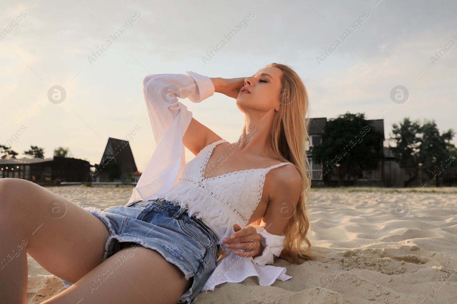 Photo of Beautiful young woman lying on sandy beach