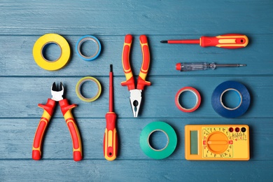 Flat lay composition with electrician's tools on wooden background