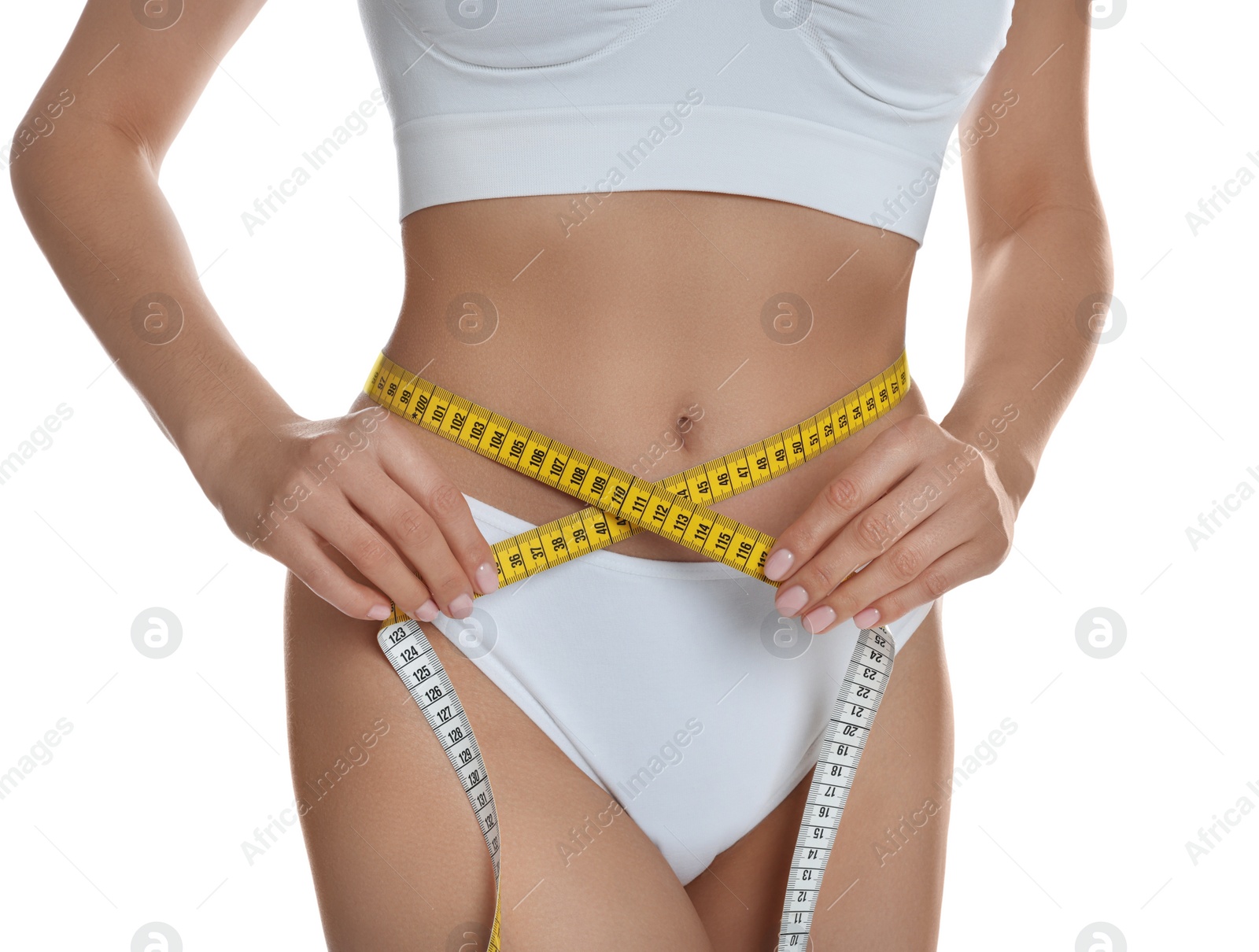 Photo of Young woman measuring waist with tape on white background, closeup