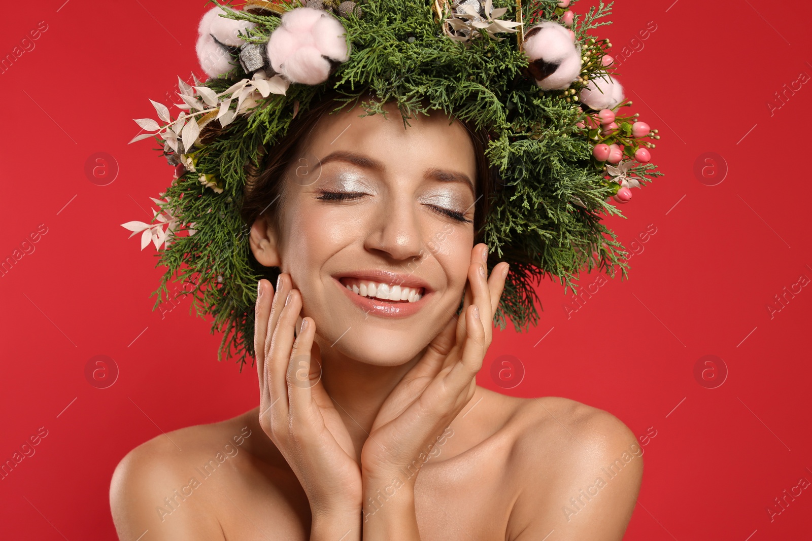 Photo of Happy young woman wearing wreath on red background