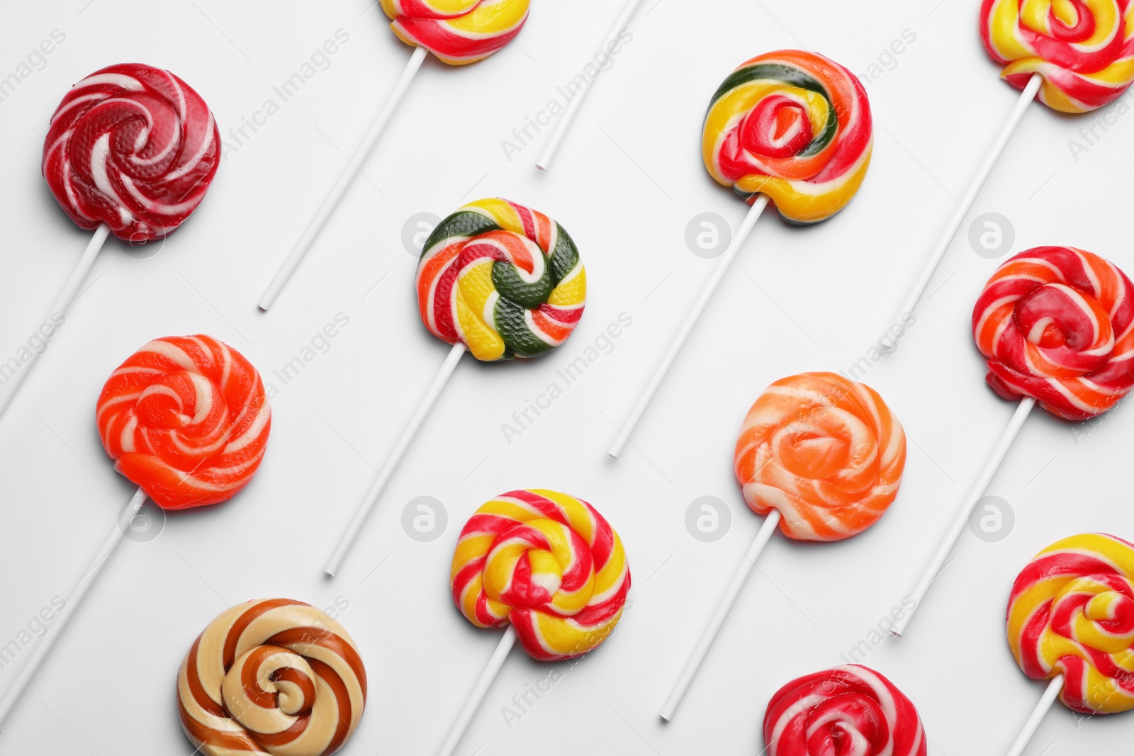 Photo of Sweet lollipops on light background, flat lay