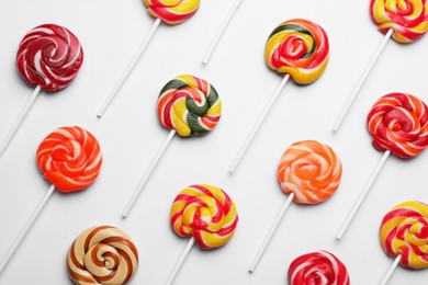 Sweet lollipops on light background, flat lay