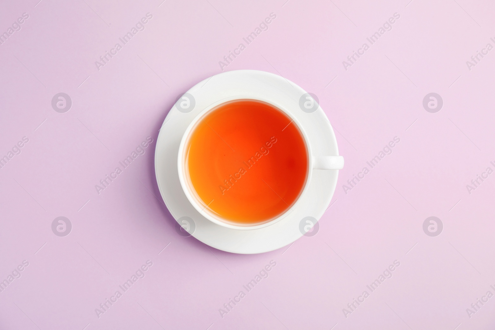 Photo of Cup of delicious tea with saucer on color background, top view