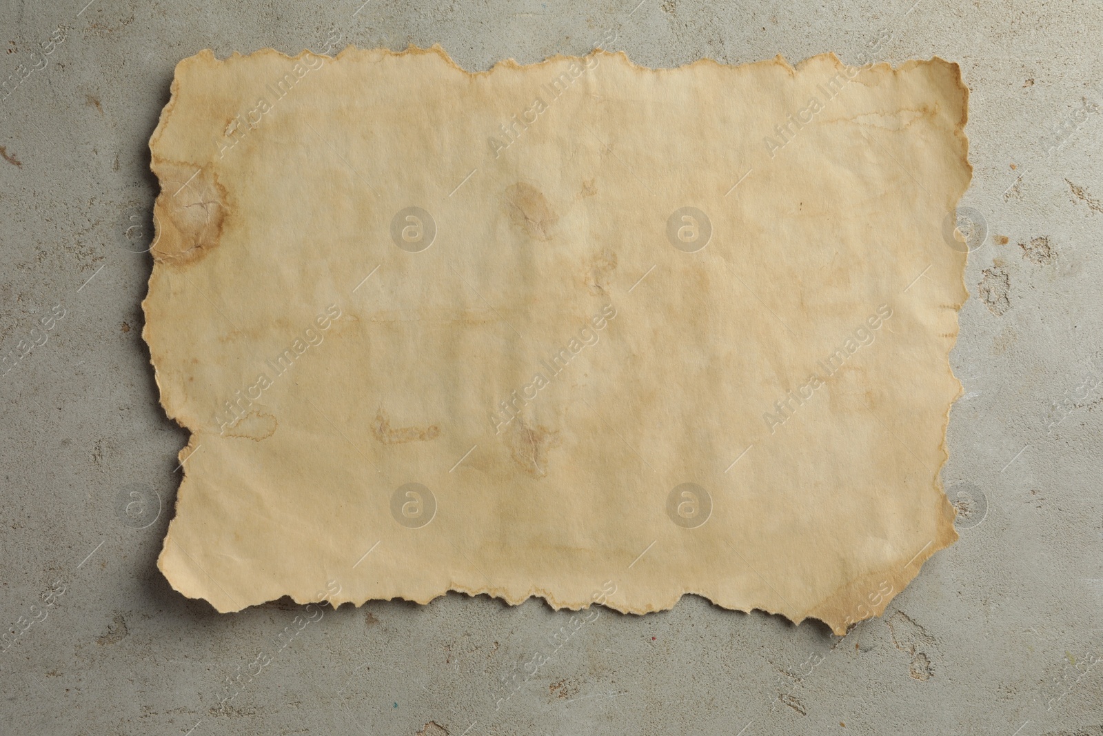 Photo of Sheet of old parchment paper on grey table, top view