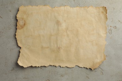 Photo of Sheet of old parchment paper on grey table, top view