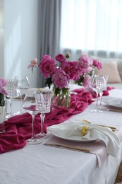 Photo of Beautiful table setting with pink peonies in dining room