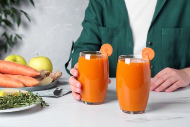 Photo of Woman taking glass with carrot juice, closeup