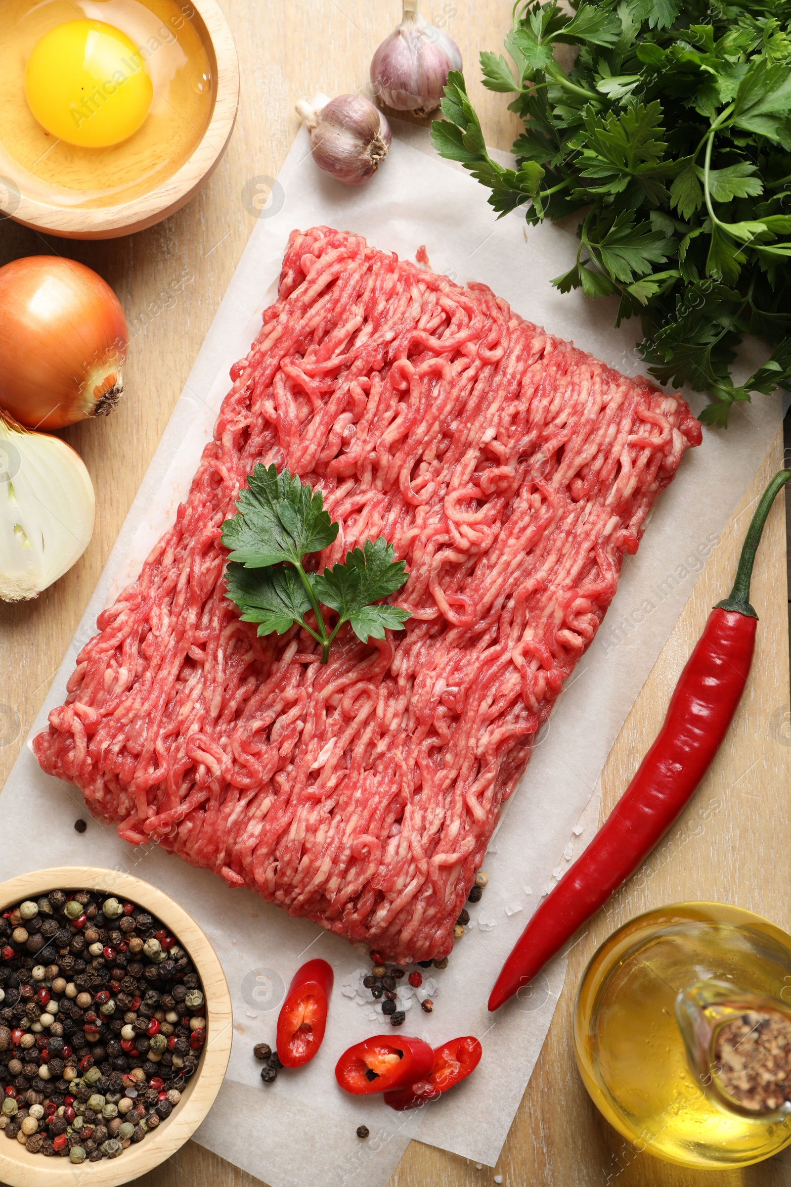 Photo of Raw ground meat and different products on table, flat lay